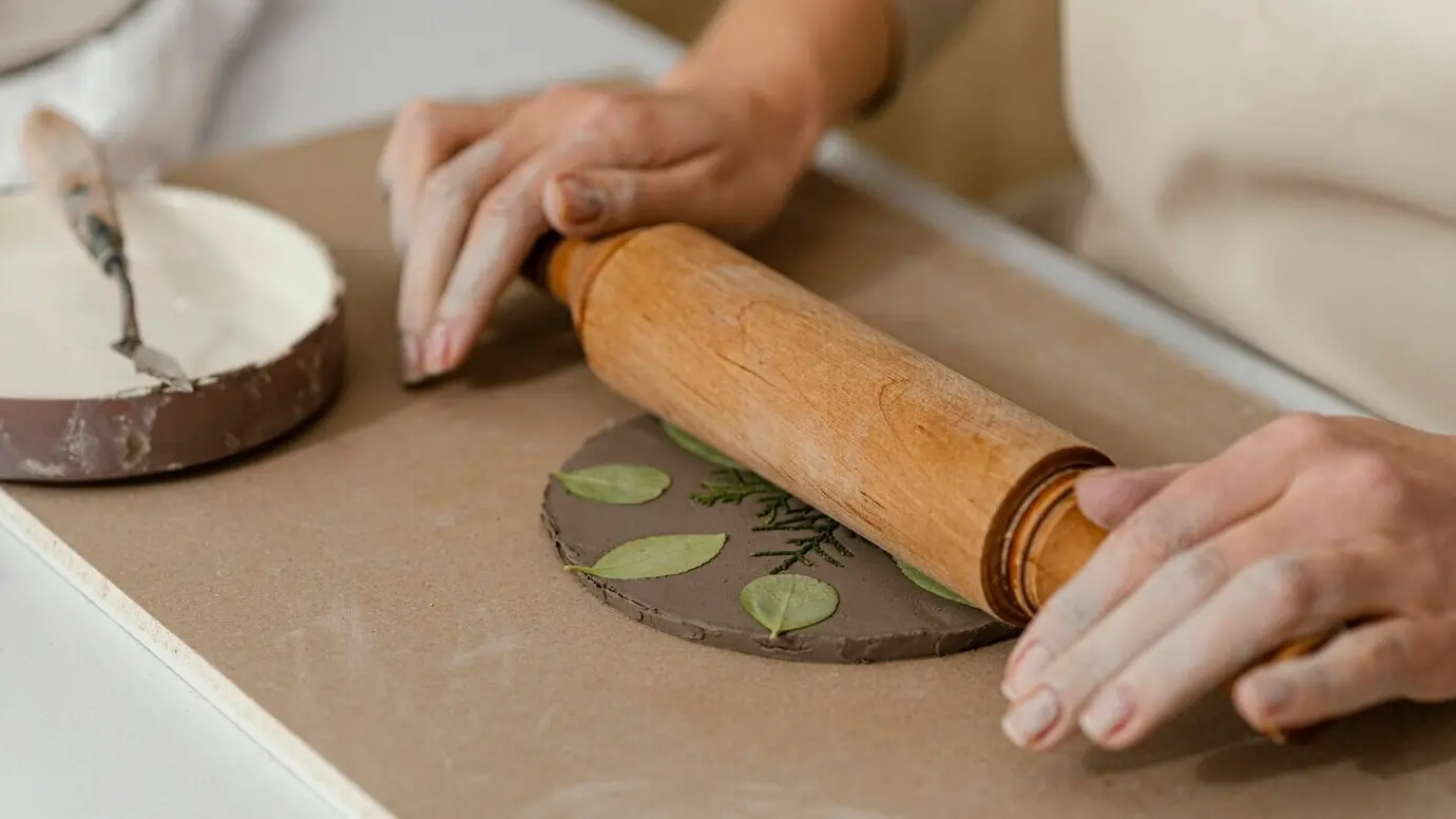 Nahaufnahme von Händen, die ein Nudelholz verwenden